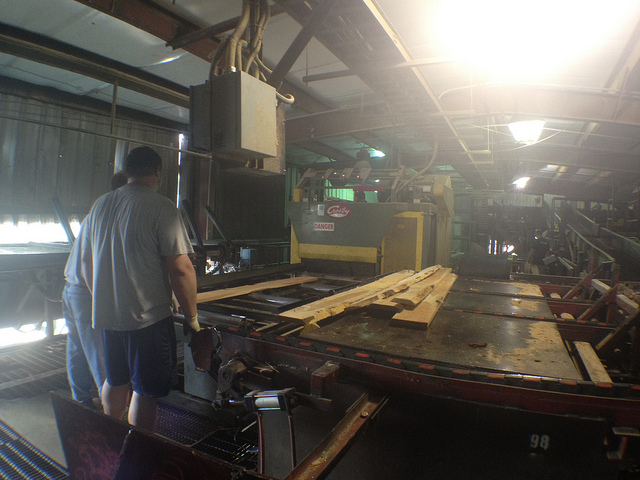 Процесс распиливания бревна на брус